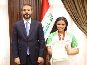 Read more about the article Dr. Al-Aboudi Congratulates Iraqi Champion, Ms. Najla Imad on Global Golden Achievement, His Excellency Delivers Her Ministerial Order to Admit Her Physical Education and Sports Sciences College